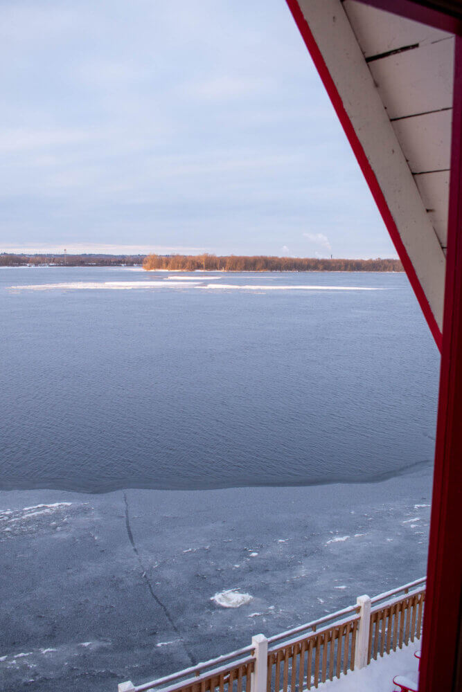 A view out of the window at the NCC River House looking towards Kettle Island. There is some ice near the building, and some small patches in the river, but for the most part the river is entirely clear of ice.